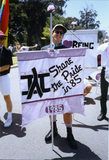 Pride parade marcher holds flag with 1985 Pride theme, 1992