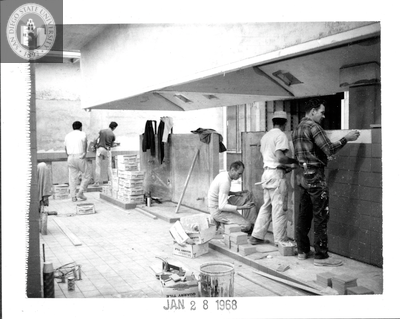 Setting tile in the kitchen, Aztec Center construction, 1968