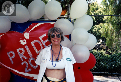 Gloria Johnson in front of poster at Pride festival, 2000