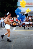 Man in sailor hat and shorts marching in Pride parade, 1991