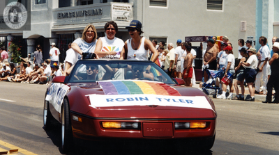 Robin Tyler and Diane Olson riding red corvette, 1996