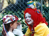 Clown painting child's face at For the Children, 1996