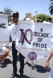 Volunteer holding flag with 1984 Pride theme in Pride parade, 1992
