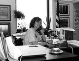 Unidentified woman at desk using telephone