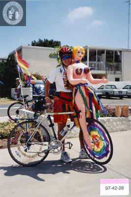 Person with blow-up doll on bicycle at Pride parade, 1997