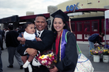 Graduate in cap and gown with husband and baby, 1999