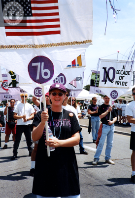 Rhonda Chase holds banner in Pride parade, 1994
