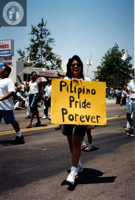 Marcher with sign "Pilipino Pride Porever" at Pride Parade, 1996