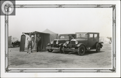 Two men with tents and two automobiles