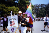 Pride parade marchers hold flags, including 1976 Pride theme, 1992