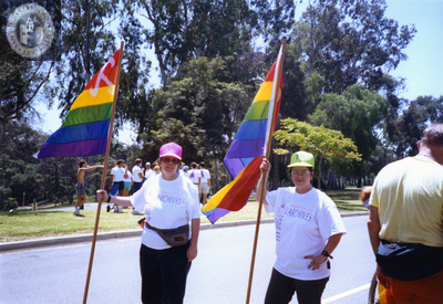 Marchers hold Lesbian and Gay Archives of San Diego rainbow flags, 1992