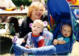 Two children in stroller with woman at For the Children, 1996