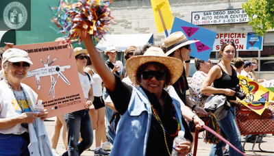 Person waving pom-pon and "Army of She" sign in Pride parade, 2001