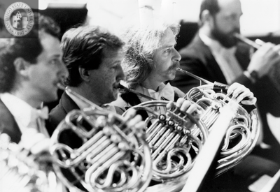 Three musicians play the french horn