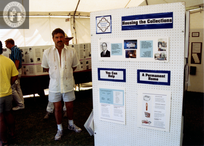 Person standing next to LGHSSD display at Pride festival, 1993