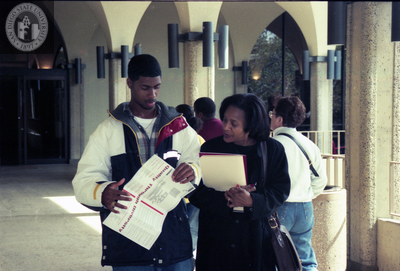 People at Aztec Center with Open House brochure, 1998