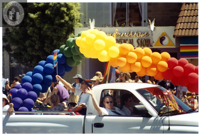Participants waving from a truck on the Pride parade route, 1999