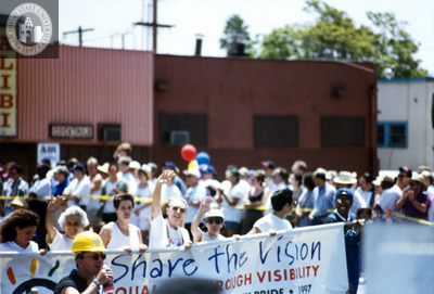 Sheila Clark, Judy Reif and others carry a banner at Pride parade, 1997