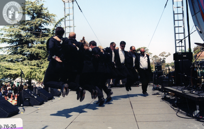 Dancers in tuxedos execute a jump at Pride Festival, 1999