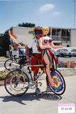 Person with blow-up doll on bicycle at Pride parade, 1997
