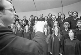 An unidentified conductor leads a chorus