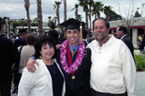 Graduate in cap and gown with parents, 1999