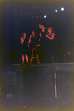 Four individuals on dark stage at Pride festival