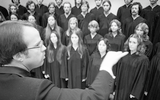 A choral conductor leads a performance