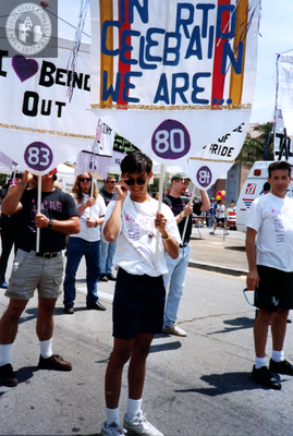Robert Nguyen holds banner in Pride parade, 1994