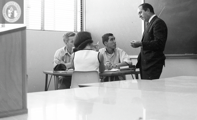 Instructor speaks with students in a workgroup