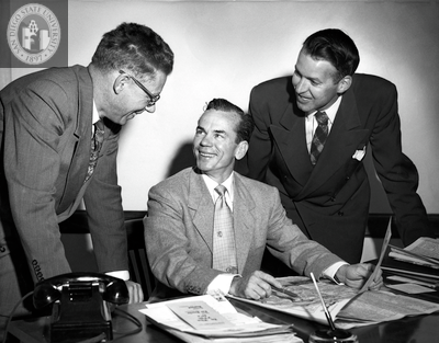 Lionel Van Deerlin stands with two other men in suits