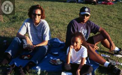 Unidentified family sitting on grass, 2000