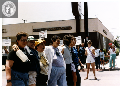 Women march with their arms around each other in Pride parade, 1988