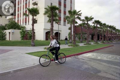 Student on bicycle near Zura Hall, 1999