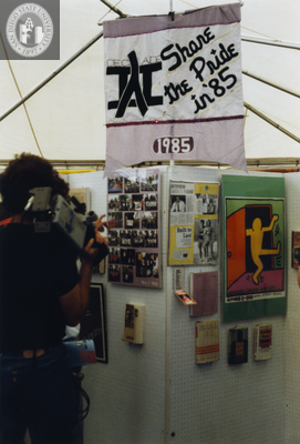 Person with television camera at exhibit, Lesbian and Gay Archives, 1991