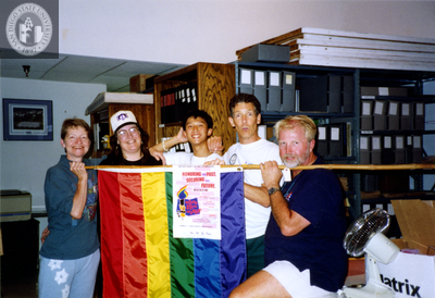 People hold a flag at the Lesbian and Gay Historical Society, 1994