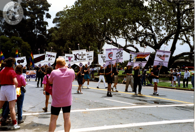 Marchers holding signs at Pride parade, 1990