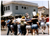 The backs of women walking with arms around each other at Pride parade, 1988