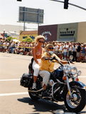 Women ride a motorcycle in Pride parade, 2001
