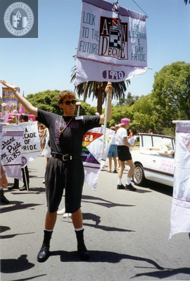Marcher with Lesbian and Gay Archives of San Diego holds flag, 1992
