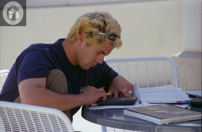 Student using calculator at Aztec Center, 1996