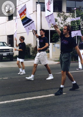 John Richardson, Glen Dake, and Jim Ely holding banners at Pride parade, 1990