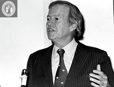 Lionel Van Deerlin speaks in close up at a microphone, 1980