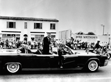 John F. Kennedy stands in convertible in motorcade, 1963