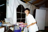 Robert Nguyen in booth at Pride festival, 1994
