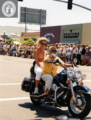 Women ride a motorcycle in Pride parade, 2001