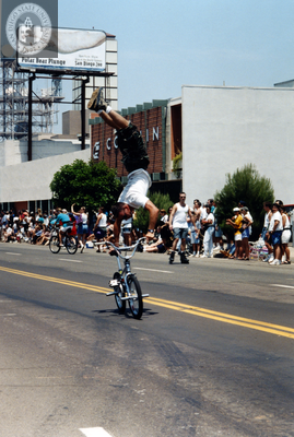 Person doing handstand on bicycle handlebars at Pride Parade, 1996