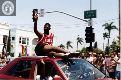 Man on top of car waving at Pride parade crowd, 1996
