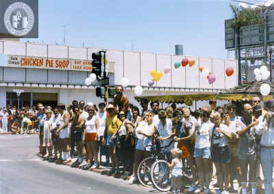 Crowd watching Pride parade in front of San Diego Chicken Pie Shop