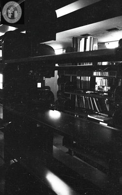 Library stacks with books, in the dark